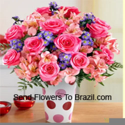 Roses roses, orchidées roses et fleurs pourpres assorties arrangées magnifiquement dans un vase en verre