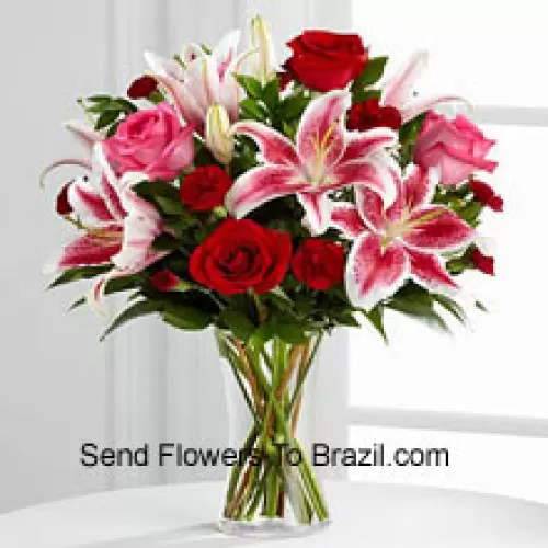 ガラス製の花瓶に赤とピンクのバラとピンクのリリー、季節の花で飾られています